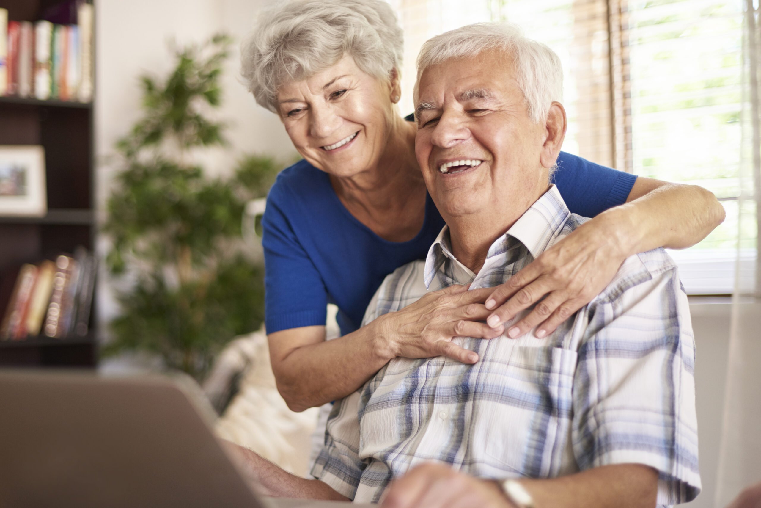happy grandparents using their digital laptop scaled - Quem se aposentou após a reforma tem direito à revisão da vida toda?